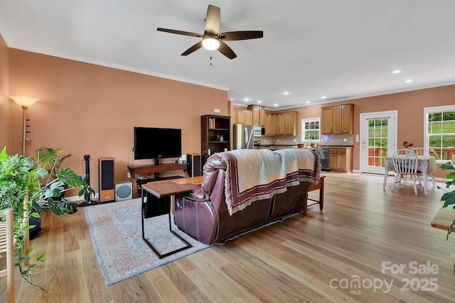 living area featuring ornamental molding, light wood finished floors, a ceiling fan, recessed lighting, and baseboards