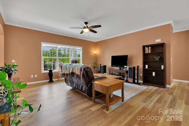 living room with a ceiling fan, light wood-style flooring, ornamental molding, and baseboards