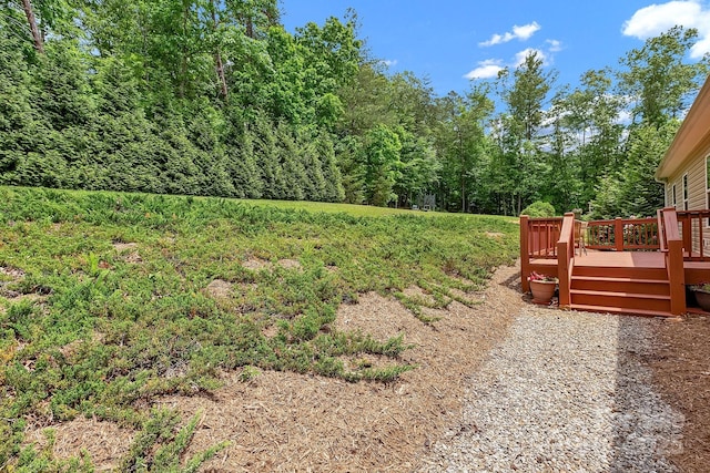 view of yard with a deck and a wooded view