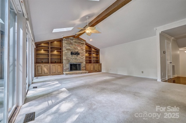 46 Timberidge Dr, Lake Wylie, SC 29710 - unfurnished living room featuring built in shelves, a skylight, a ceiling fan, a stone fireplace, and carpet flooring