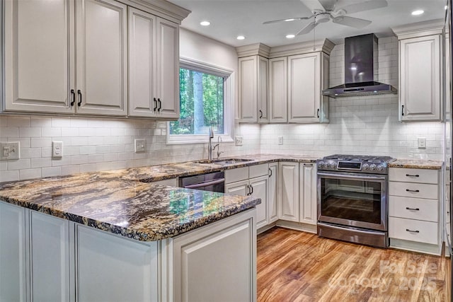 46 Timberidge Dr, Lake Wylie, SC 29710 - kitchen with gas range, wall chimney range hood, a sink, light wood finished floors, and ceiling fan
