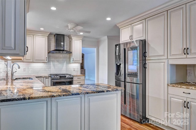 46 Timberidge Dr, Lake Wylie, SC 29710 - kitchen featuring wall chimney exhaust hood, appliances with stainless steel finishes, a sink, a ceiling fan, and dark stone countertops