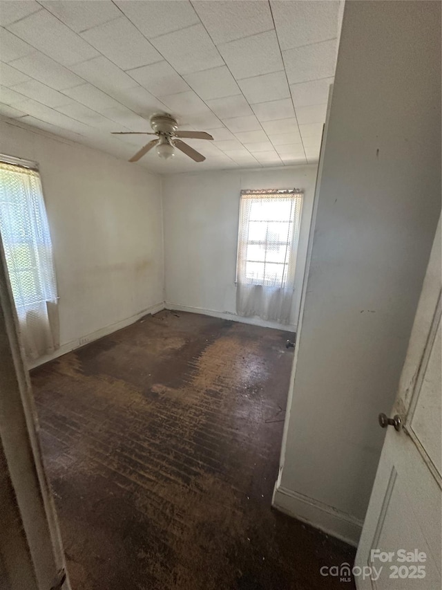 empty room featuring a ceiling fan and wood-type flooring