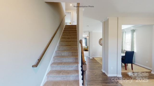 staircase featuring wood finished floors and baseboards