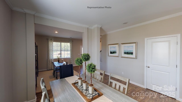 dining area featuring crown molding, baseboards, and wood finished floors