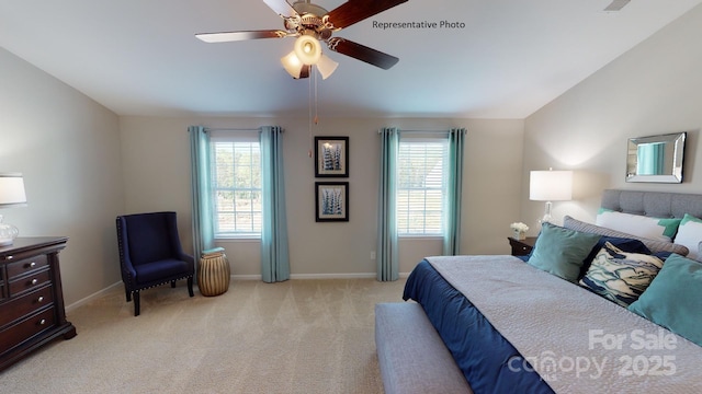 bedroom with multiple windows, light carpet, and baseboards