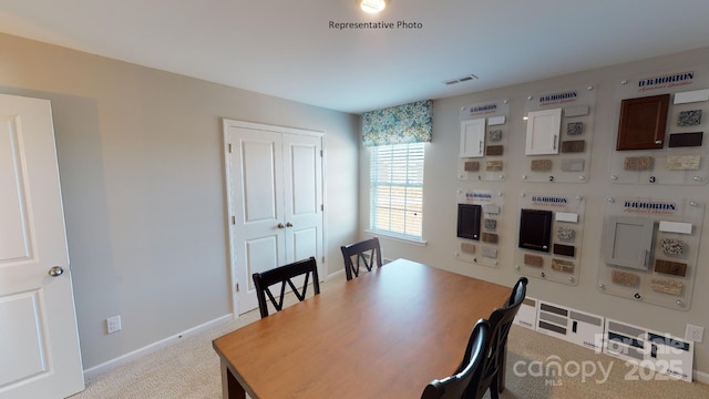 dining space featuring light carpet and baseboards