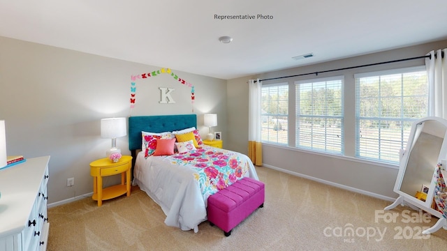 bedroom featuring light carpet and baseboards