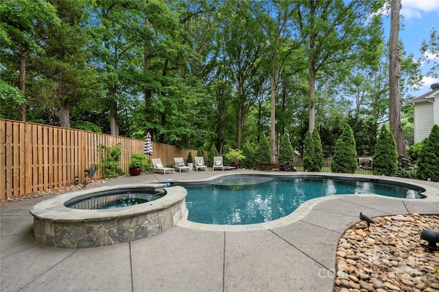 view of swimming pool featuring a fenced backyard, a patio, and a pool with connected hot tub