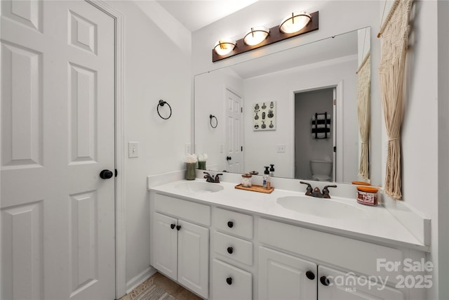 full bathroom featuring toilet and double vanity