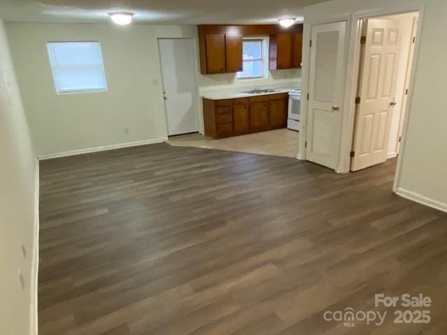 5309 Lewis Rd, Gastonia, NC 28052 - kitchen with brown cabinets, dark wood finished floors, baseboards, light countertops, and range