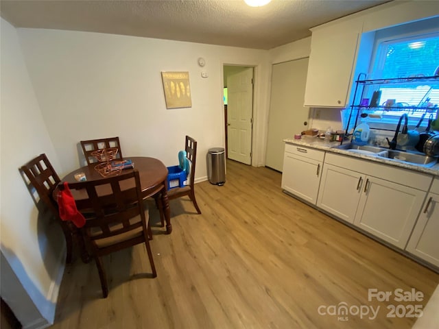 5309 Lewis Rd, Gastonia, NC 28052 - dining area with light wood-style flooring, a textured ceiling, and baseboards