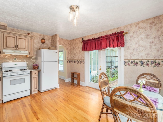 10 Gardening Frog Trl, Waynesville, NC 28785 - kitchen with white appliances, under cabinet range hood, wallpapered walls, light wood finished floors, and a textured ceiling