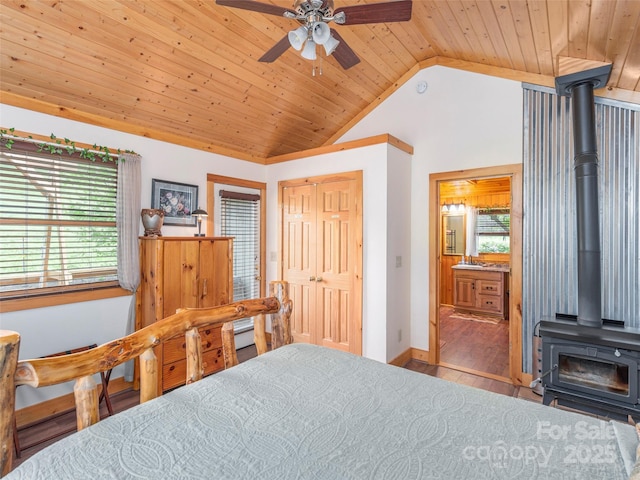 10 Gardening Frog Trl, Waynesville, NC 28785 - bedroom featuring a wood stove, vaulted ceiling, wood ceiling, wood finished floors, and baseboards