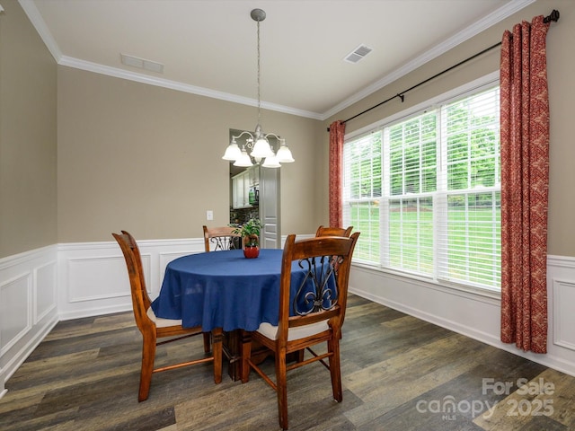 3224 Dunbar Ln, Fort Mill, SC 29707 - dining space featuring a chandelier, dark wood finished floors, ornamental molding, and wainscoting