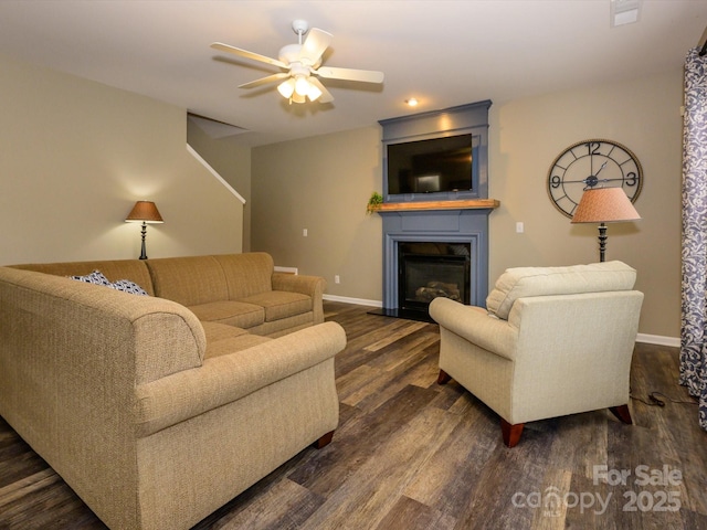 3224 Dunbar Ln, Fort Mill, SC 29707 - living area with dark wood-type flooring, a ceiling fan, baseboards, and a glass covered fireplace