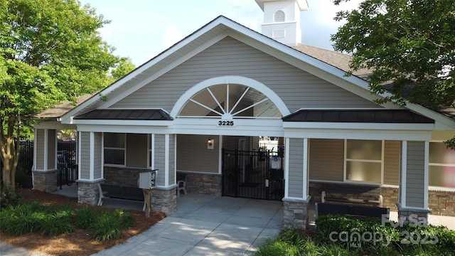 3224 Dunbar Ln, Fort Mill, SC 29707 - view of front of home with covered porch, a standing seam roof, stone siding, metal roof, and a shingled roof