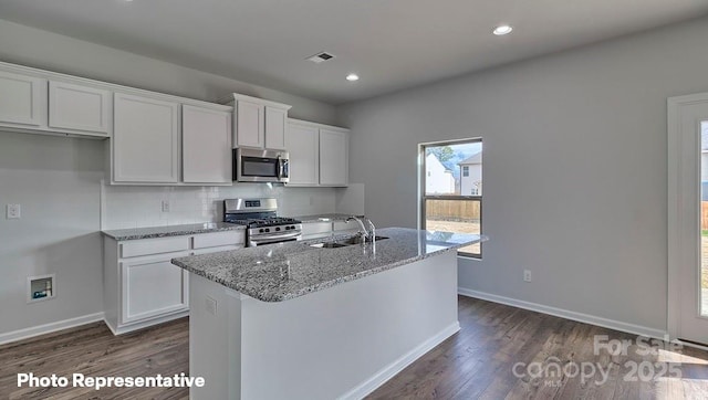 kitchen featuring stainless steel appliances, a sink, white cabinetry, dark wood-style flooring, and recessed lighting