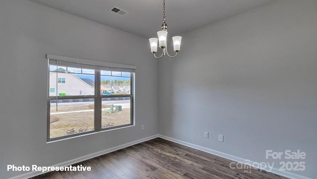 unfurnished room with a chandelier, dark wood-type flooring, and baseboards