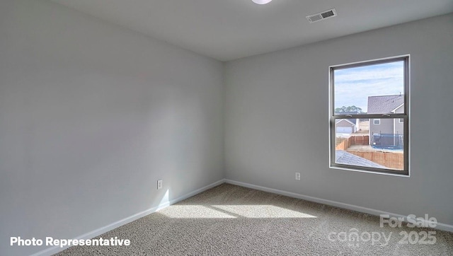 spare room featuring carpet flooring and baseboards