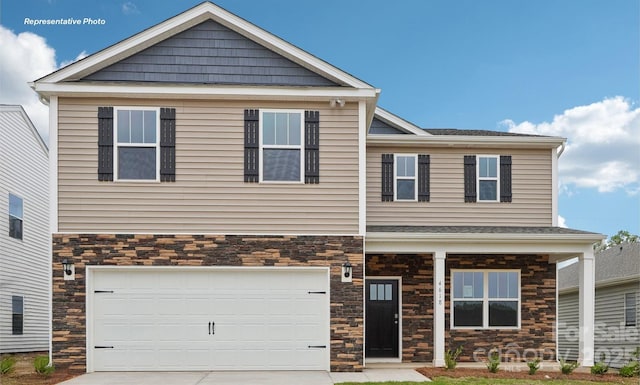 craftsman-style house featuring stone siding, driveway, and an attached garage