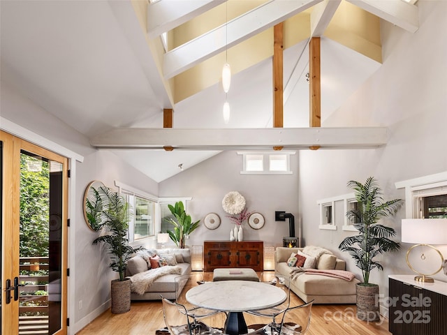 11 Kenilworth Rd, Asheville, NC 28803 - living area with high vaulted ceiling, light wood finished floors, beamed ceiling, a wood stove, and baseboards