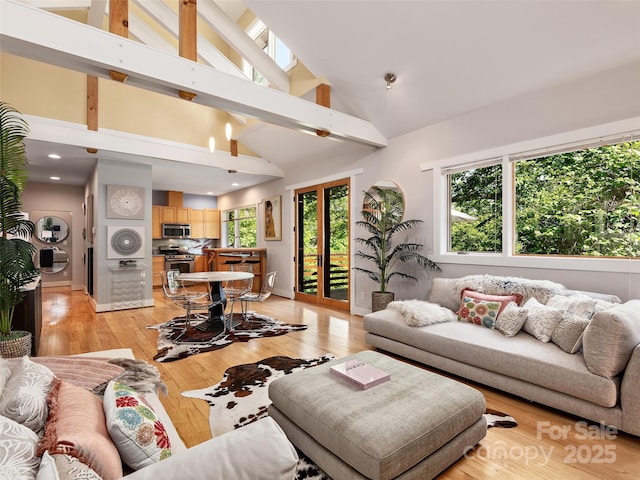 11 Kenilworth Rd, Asheville, NC 28803 - living area with stacked washing machine and dryer, high vaulted ceiling, and light wood finished floors