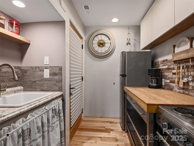 11 Kenilworth Rd, Asheville, NC 28803 - kitchen with a sink, open shelves, light wood-type flooring, stainless steel range, and recessed lighting