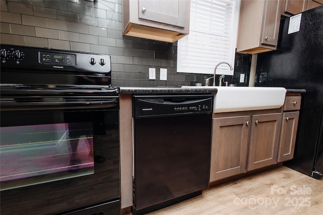 3499 Fairview Rd, Nebo, NC 28761 - kitchen featuring black appliances, tasteful backsplash, light wood-style floors, dark countertops, and a sink
