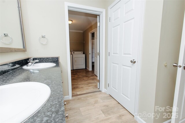 3499 Fairview Rd, Nebo, NC 28761 - bathroom with crown molding, double vanity, wood finished floors, and independent washer and dryer