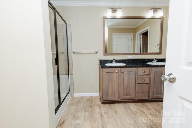 3499 Fairview Rd, Nebo, NC 28761 - bathroom featuring a shower stall, wood finished floors, double vanity, and crown molding