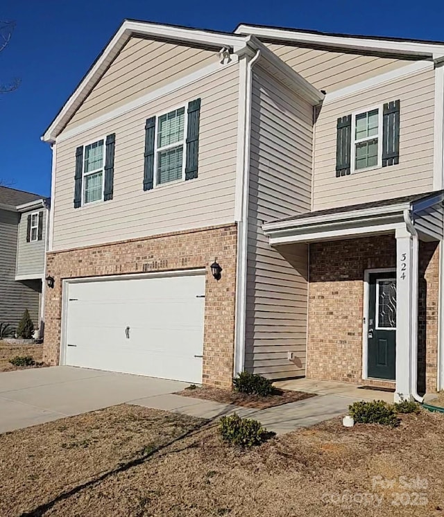 view of front facade with brick siding, an attached garage, and driveway