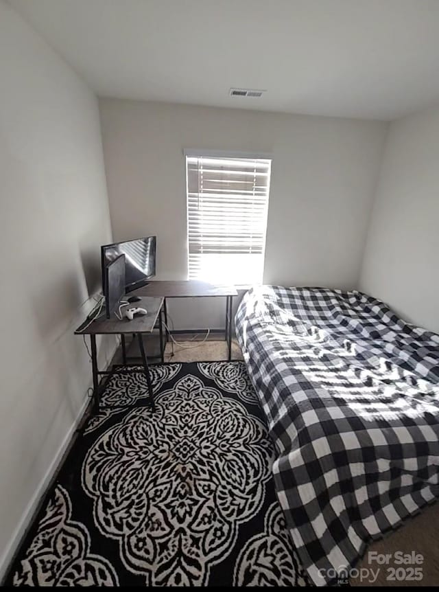 bedroom featuring carpet, baseboards, and an office area