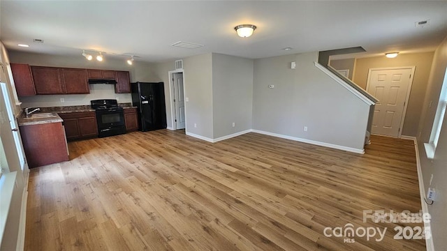 5823 Natick Dr, Charlotte, NC 28214 - kitchen featuring black appliances, under cabinet range hood, baseboards, light wood-style floors, and a sink