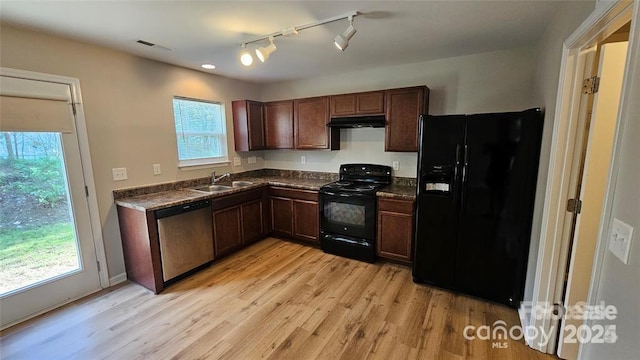 5823 Natick Dr, Charlotte, NC 28214 - kitchen featuring black appliances, dark countertops, light wood finished floors, a sink, and under cabinet range hood