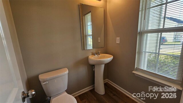 5823 Natick Dr, Charlotte, NC 28214 - bathroom with plenty of natural light, toilet, baseboards, and wood finished floors