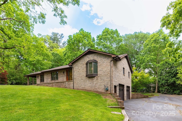 109 Wilkie Way, Fletcher, NC 28732 - view of property exterior with an attached garage, asphalt driveway, a yard, and brick siding