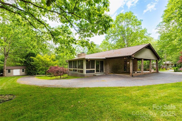 109 Wilkie Way, Fletcher, NC 28732 - rear view of house featuring a sunroom, asphalt driveway, an outdoor structure, a chimney, and a yard