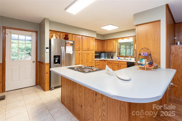 109 Wilkie Way, Fletcher, NC 28732 - kitchen featuring stainless steel appliances, light countertops, a peninsula, brown cabinetry, and wainscoting