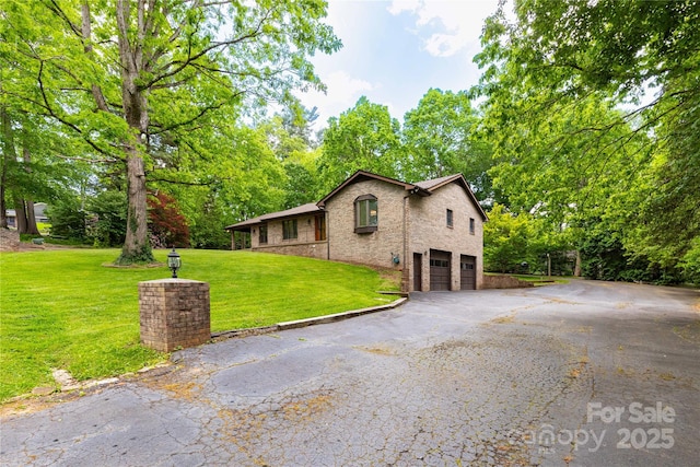 109 Wilkie Way, Fletcher, NC 28732 - view of front of property featuring an attached garage, asphalt driveway, brick siding, and a front yard