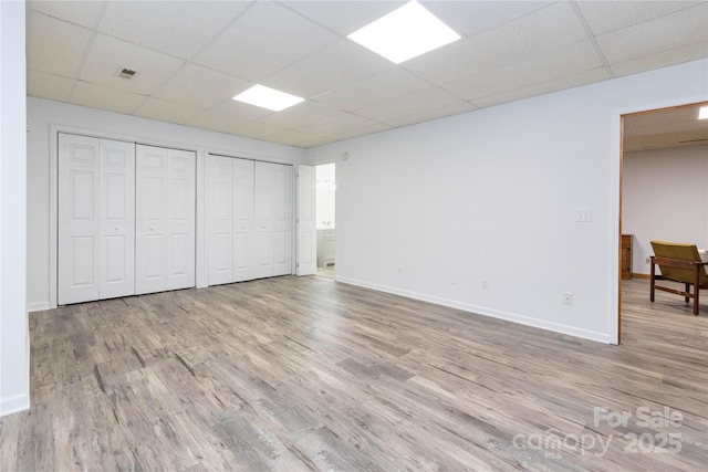 109 Wilkie Way, Fletcher, NC 28732 - unfurnished bedroom featuring a drop ceiling, wood finished floors, baseboards, multiple closets, and ensuite bath