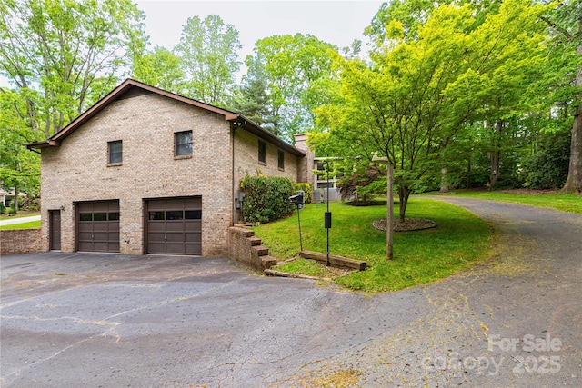 109 Wilkie Way, Fletcher, NC 28732 - view of home's exterior with a garage, asphalt driveway, brick siding, and a yard