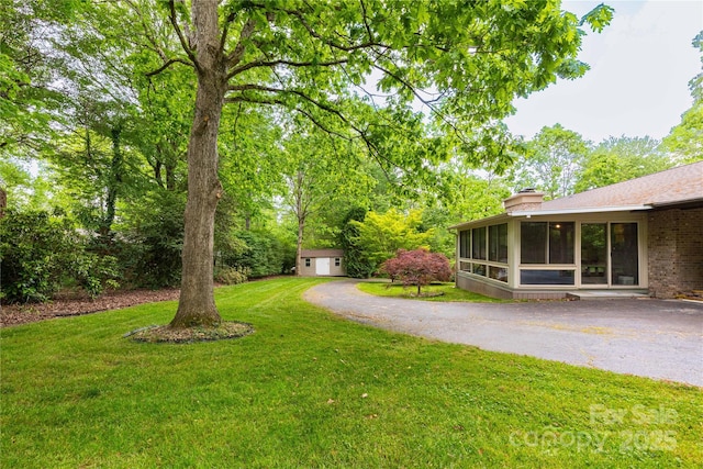 109 Wilkie Way, Fletcher, NC 28732 - view of green lawn featuring a sunroom, an outbuilding, and driveway