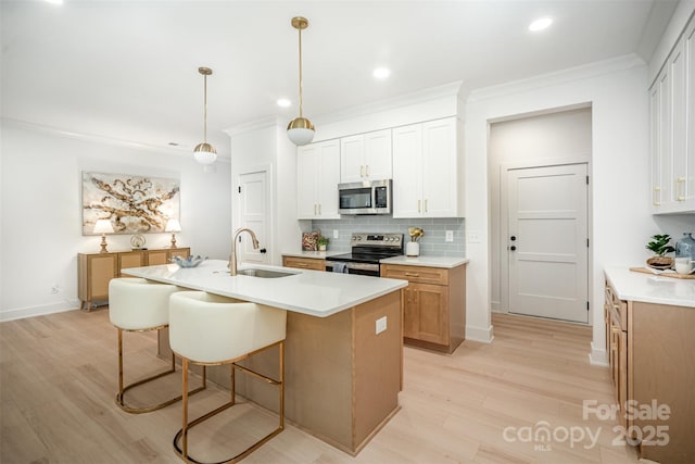 4547 Kings Ct, Hickory, NC 28602 - kitchen featuring appliances with stainless steel finishes, light wood-type flooring, backsplash, a breakfast bar area, and light countertops