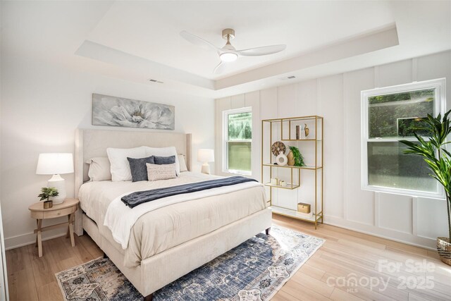 4547 Kings Ct, Hickory, NC 28602 - bedroom featuring a tray ceiling, light wood-type flooring, and ceiling fan