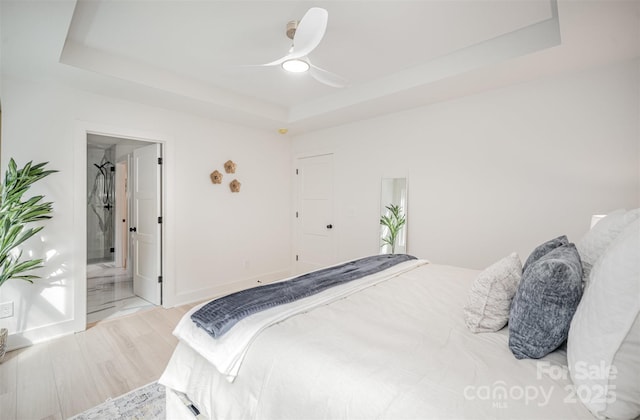 4547 Kings Ct, Hickory, NC 28602 - bedroom featuring a tray ceiling, wood finished floors, ensuite bath, and a ceiling fan