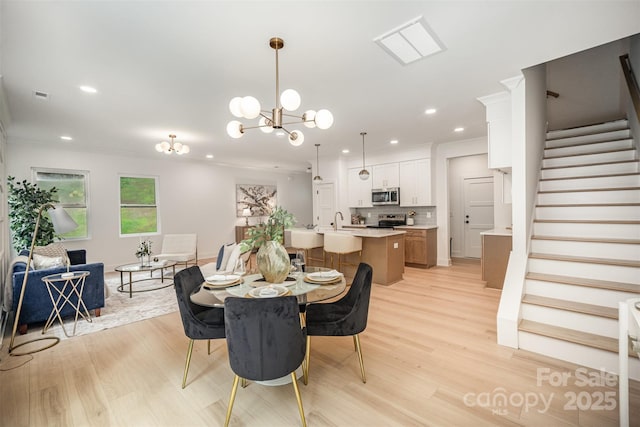 4547 Kings Ct, Hickory, NC 28602 - dining room featuring crown molding, a chandelier, light wood-style flooring, recessed lighting, and stairs