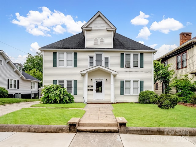 view of front of home featuring a front yard and roof with shingles