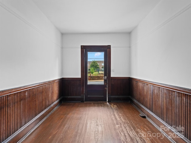 spare room featuring hardwood / wood-style floors, wainscoting, and wooden walls