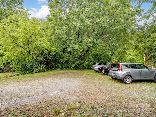 uncovered parking lot featuring fence